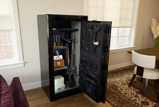 Open black Liberty gun safe in a home setting, showing interior shelving with stored items and a fabric-lined door panel.